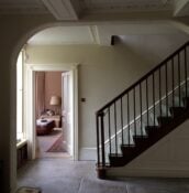 Hallway in shade showing walls painted in Stone White and staircase.