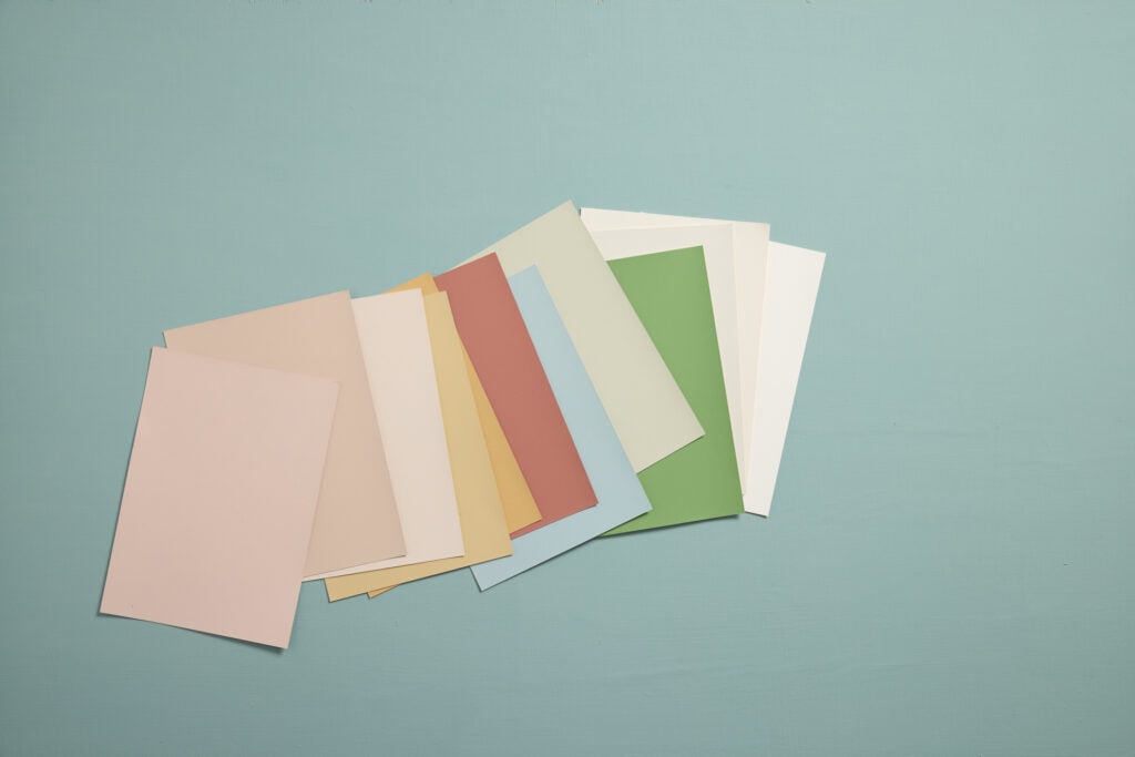 Layout of A5 colour cards showing different Edward Bulmer Natural Paint colours on a blue backdrop
